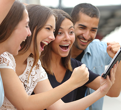 3 girls and 1 boy celebrating with phone